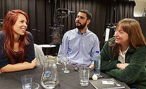 Tre doktorander sitter runt ett bord 